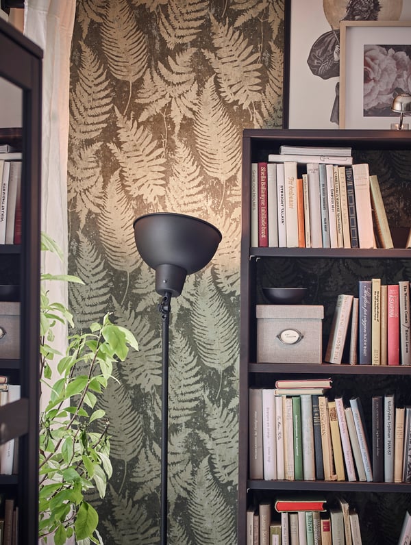 IKEA SKURUP black standing lamp, with lampshade turned upwards to provide wide, general lighting.