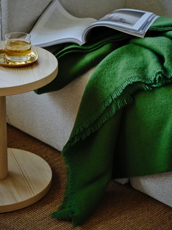 A green STOCKHOLM 2025 throw in the living room
