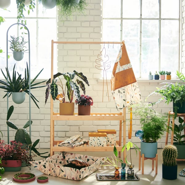 Un estante para plantas DAKSJUS conmaceteros en el interior y alrededor.