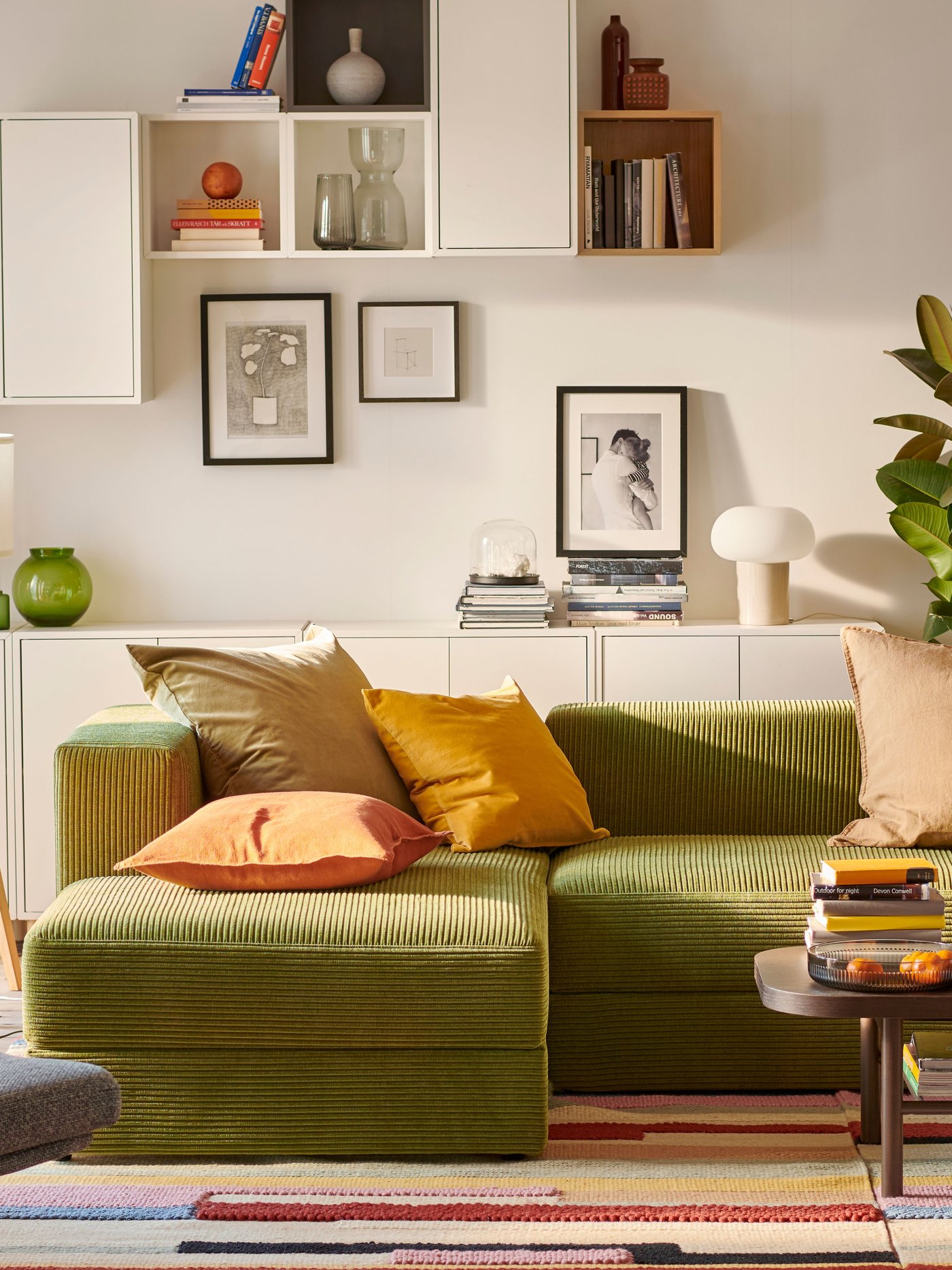 Un soggiorno luminoso incentrato su un divano a tre posti e mezzo JÄTTEBO con chaise longue e armadi a muro EKET.