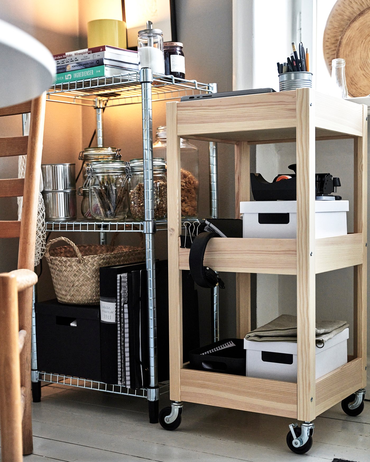 En rullvagn i trä står bredvid en hylla i metall.
