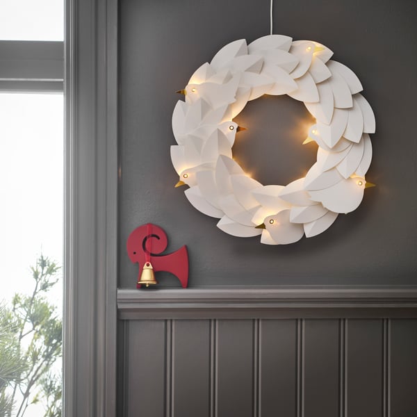 STRÅLA christmas wreath with LED lights hanging on a grey wall ina christmas decorated house.