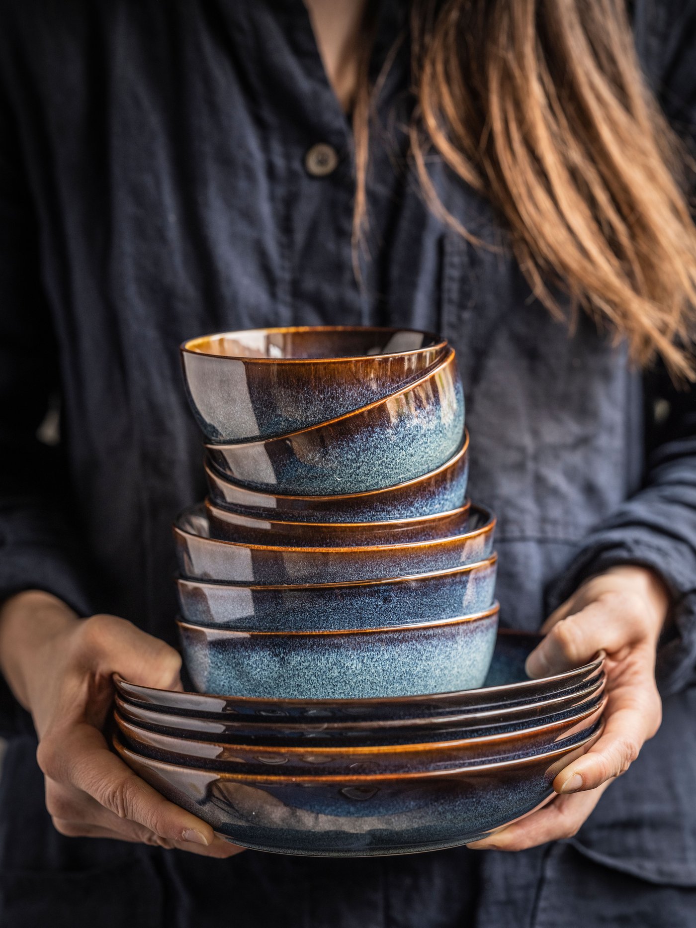 Persona tomando vajilla azul con bordes cafés.