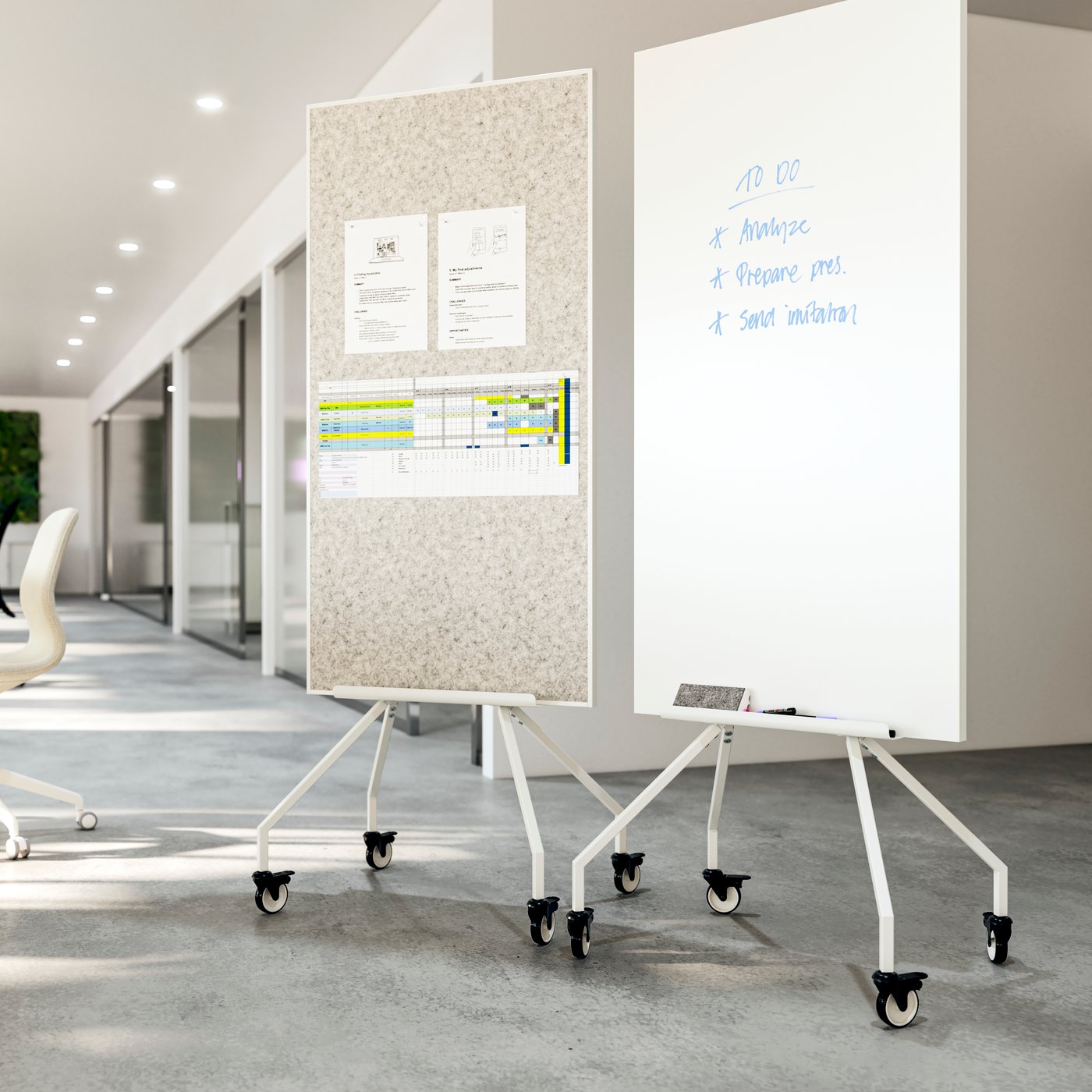 Two ELLOVEN whiteboards/noticeboards on wheels next to each other in an airy office. Double-sided, for notes and for writing.