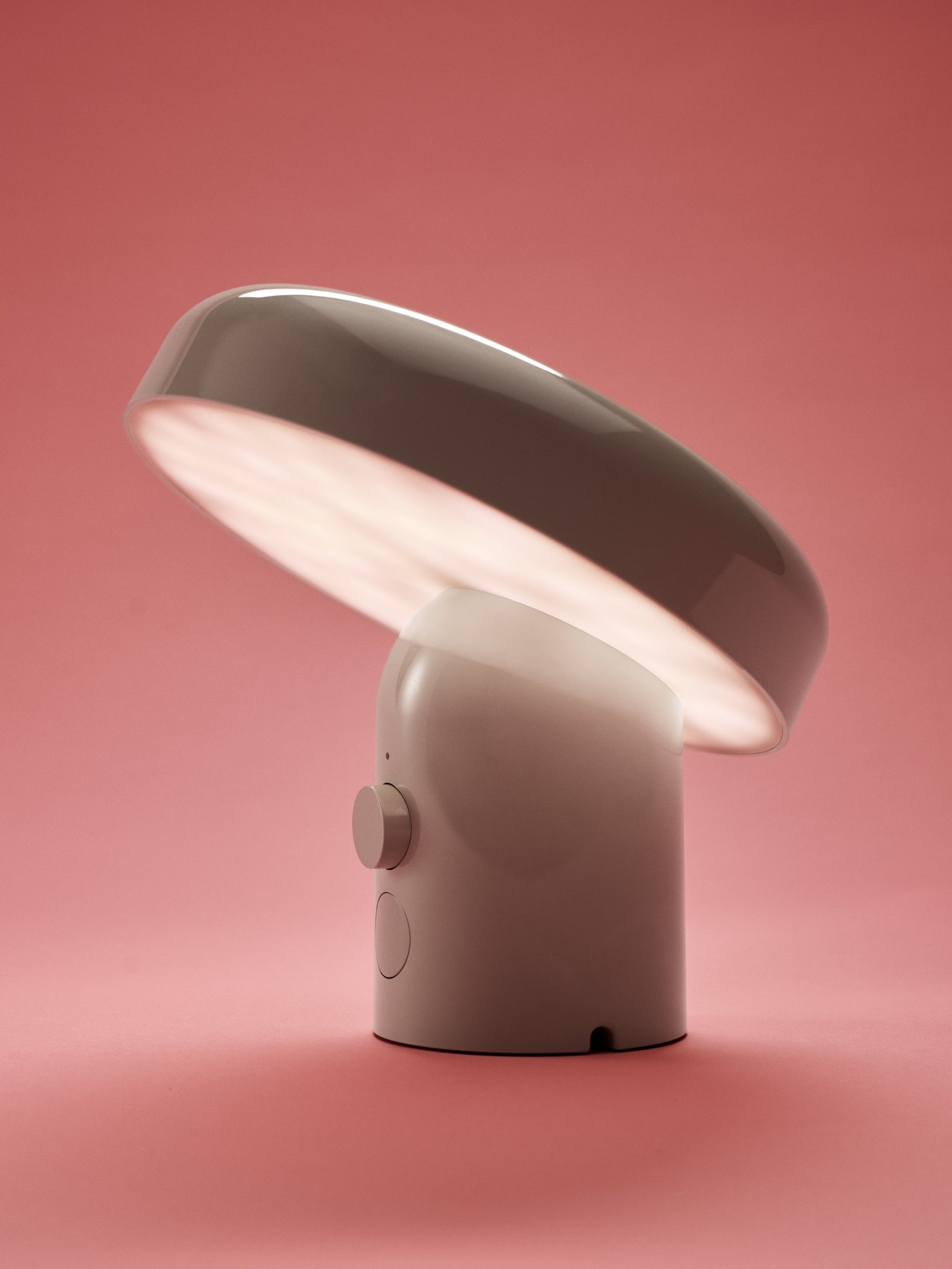 En beige EKENASET lampe med Bluetooth-højttaler på lyserød baggrund