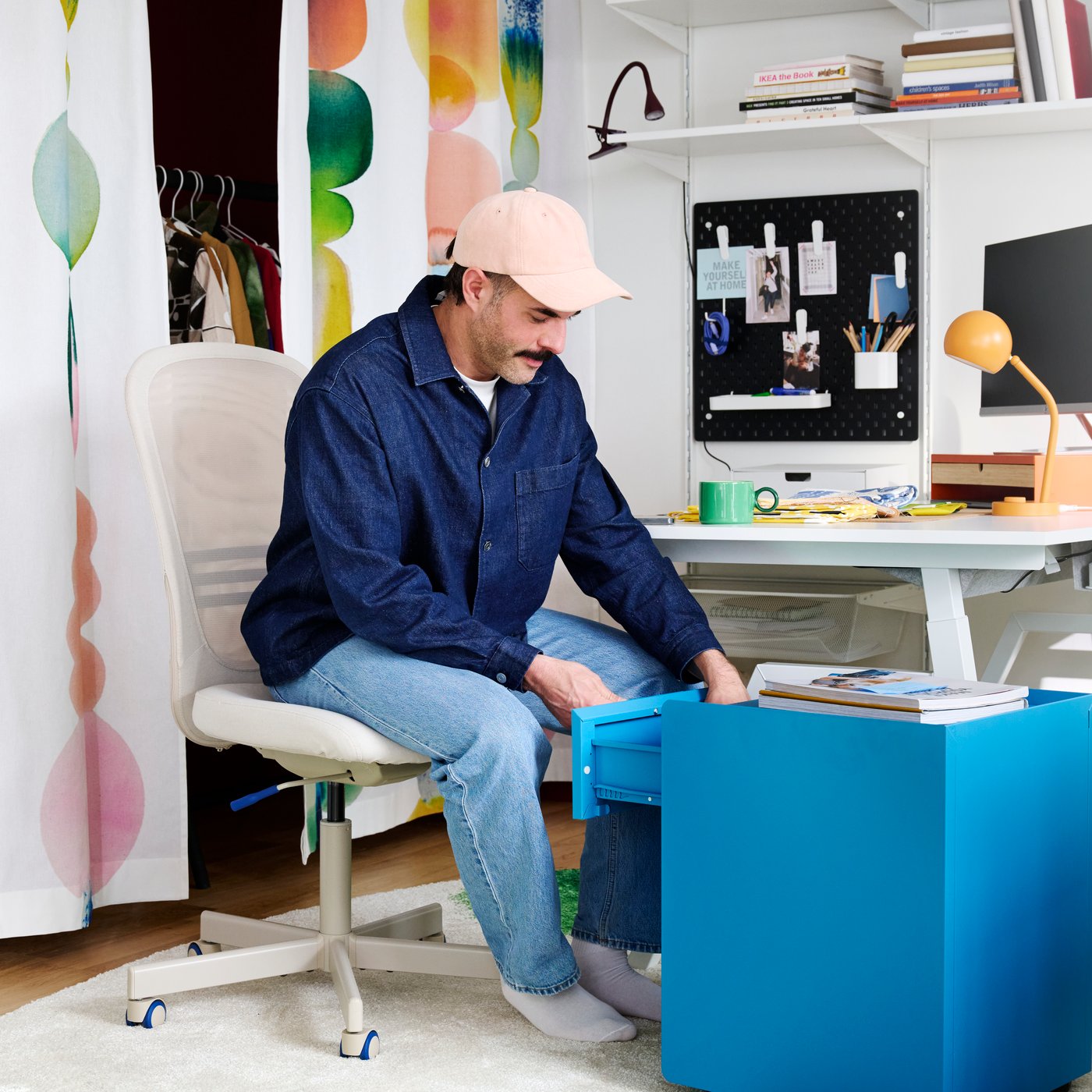An office space features a beige FLINTAN office chair with a comfortable design near a desk and shelves with stationery.