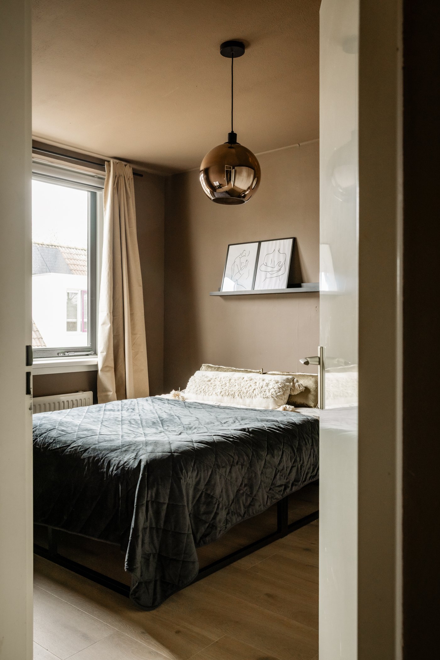 Slaapkamer, gezien door de opening van een deur.