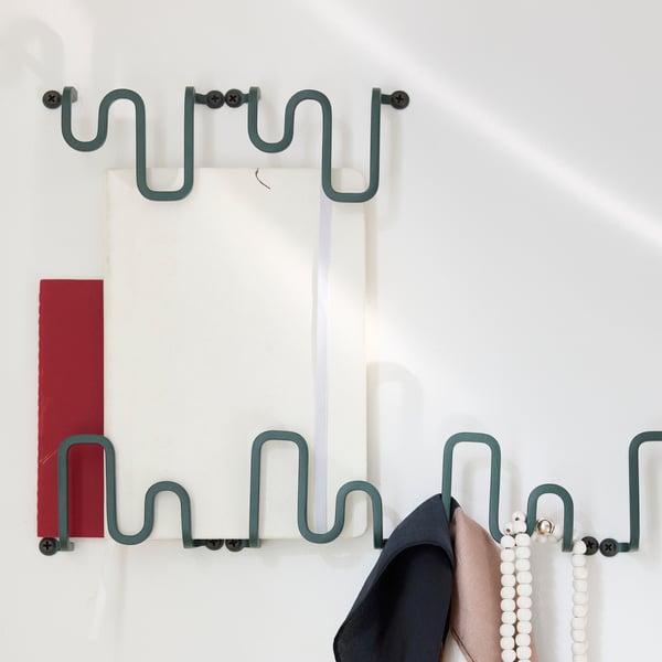 A combination of wall-mounted JORDMÅNE hooks with a few things hanging on them.