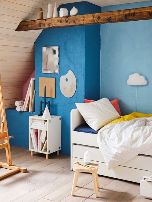Children’s bedroom with bed frame with underbed and storage, wall lamp with LED, children’s stool, toys, storage unit.