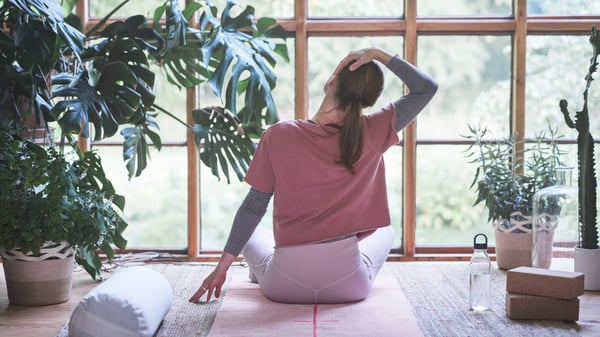 En dame gjør yoga i stuen.
