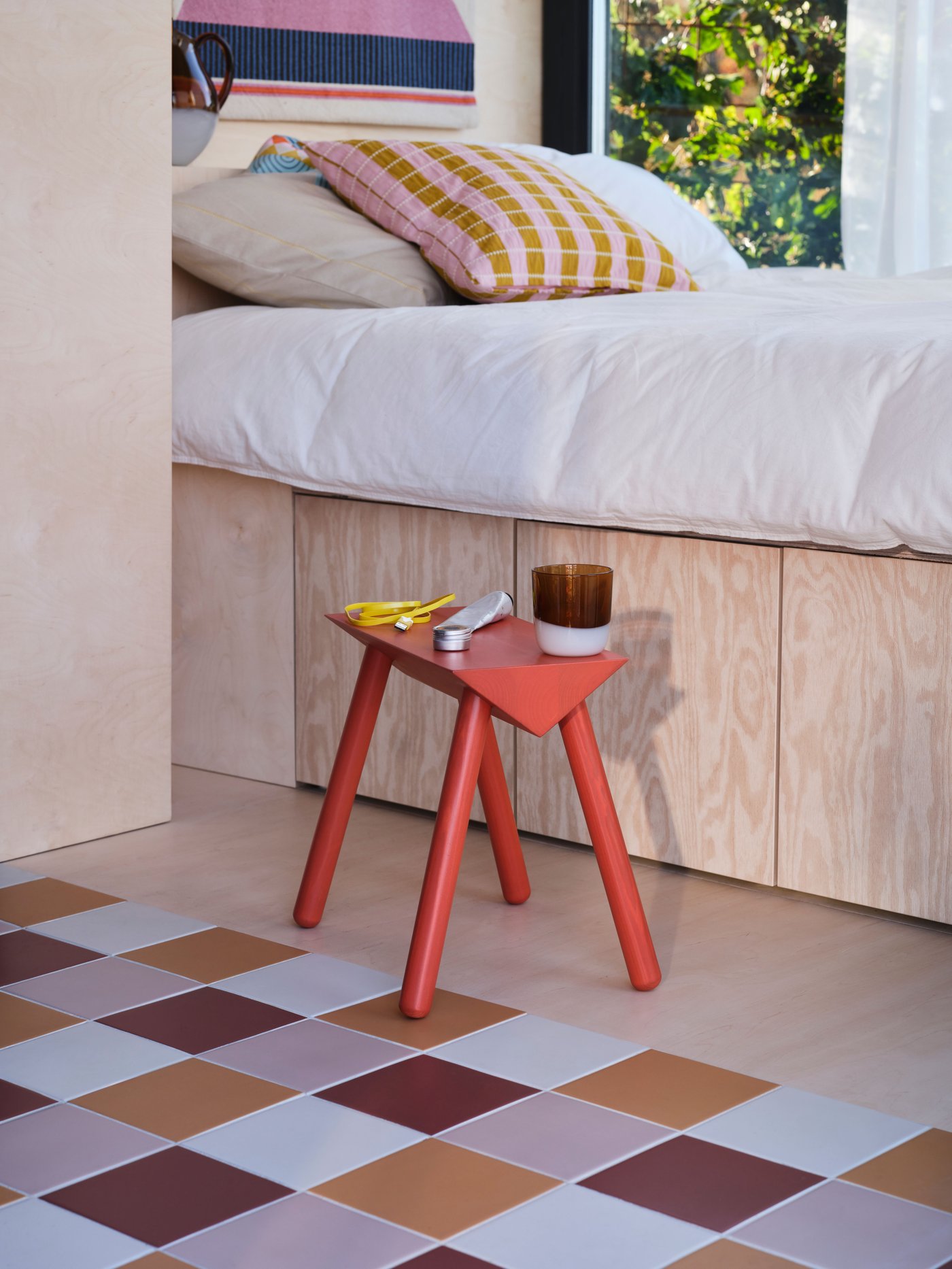 Una brocca OMMJÄNGE in vetro/marrone in camera da letto e un tappeto a quadri di divesi toni di marrone