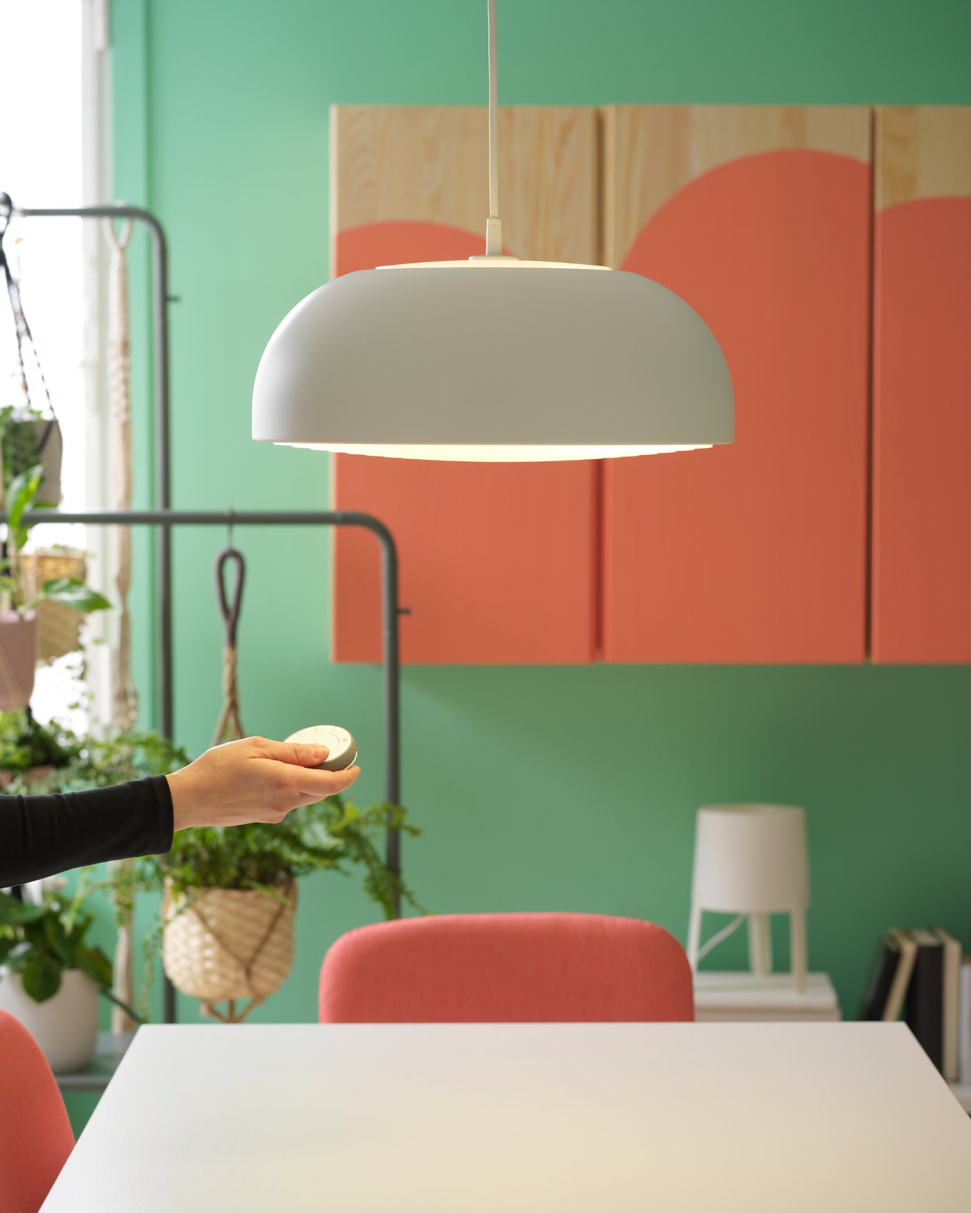 A white NYMÅNE pendant lamp in the dining room