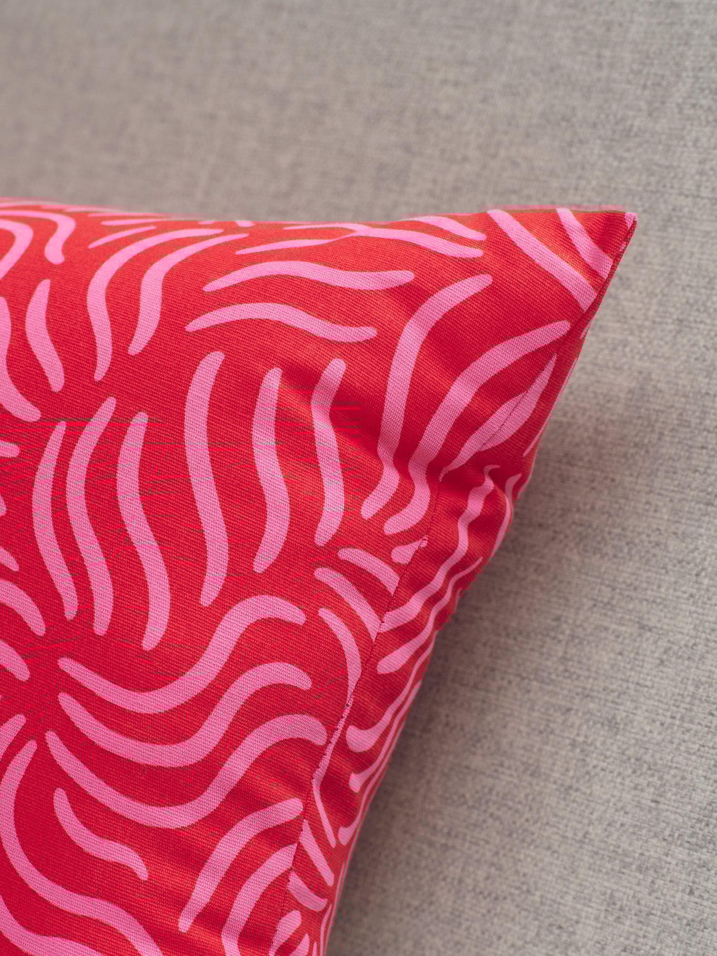 A bright red/bright pink SANDMOTT cushion