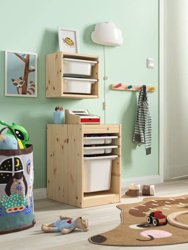 Un dormitorio infantil con un mueble TROFAST de estructura de madera y cajas blancas.