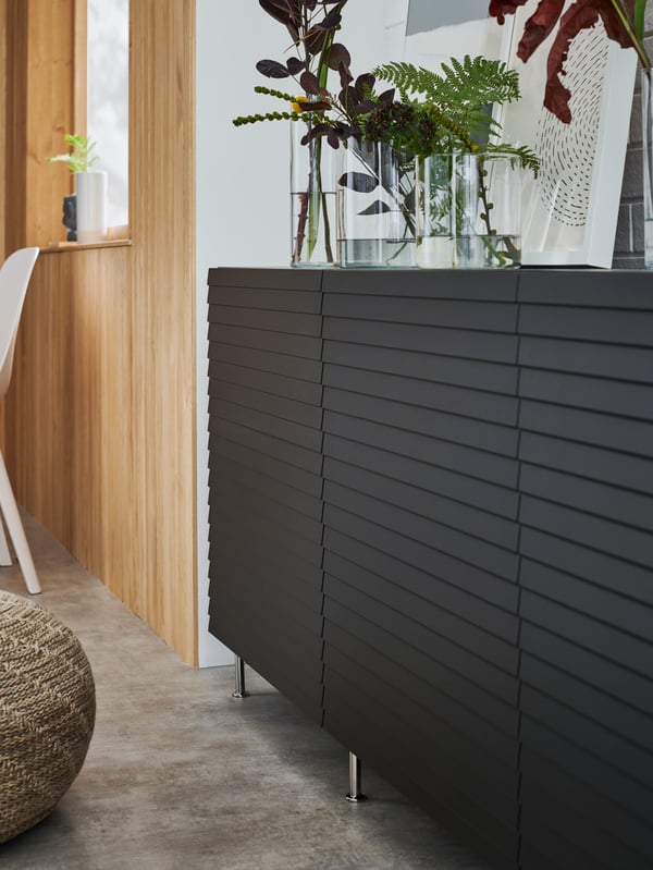 Close-up of a BESTÅ storage combination with black-brown STOCKVIKEN doors in a living room setting.