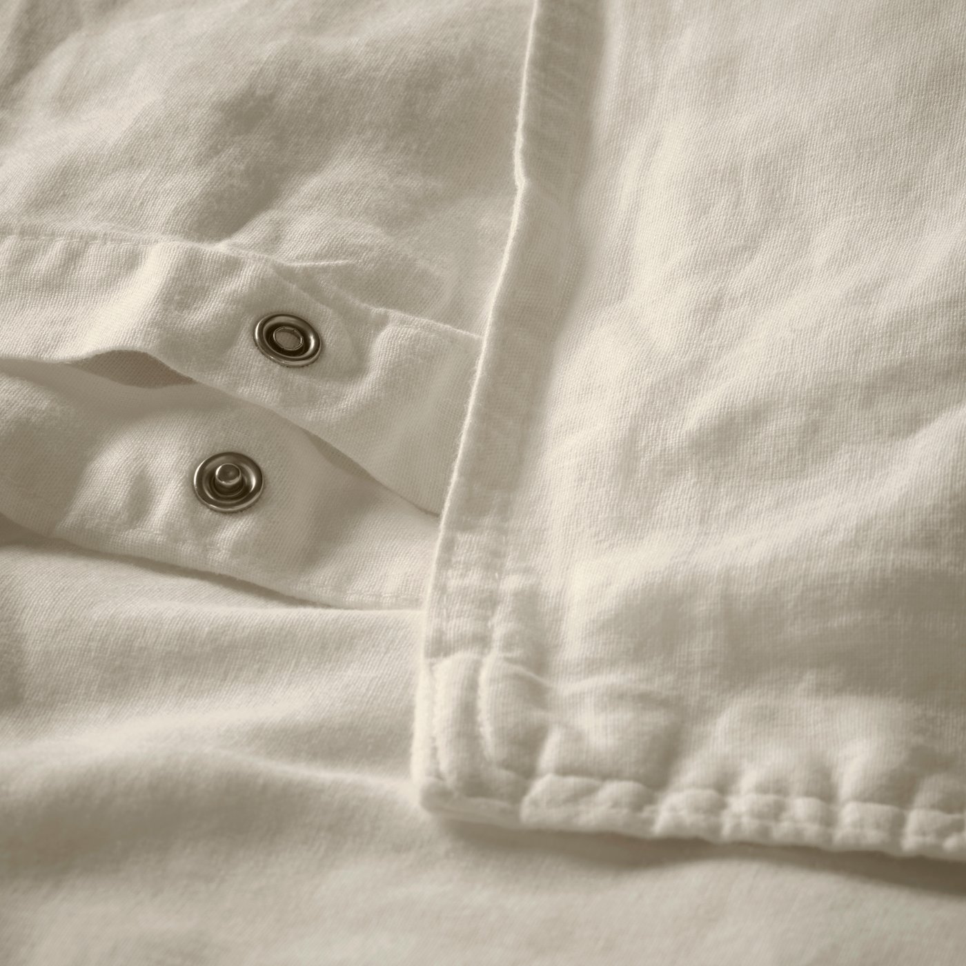 Beige RUNDHAGTORN-pussilakana ja tyynyliina lähikuvassa.