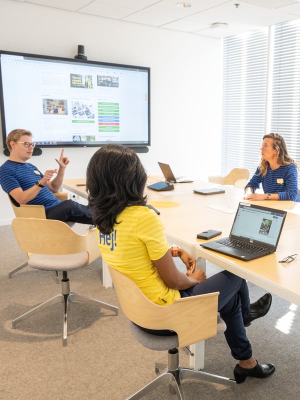 Several co-workers in a meeting room.