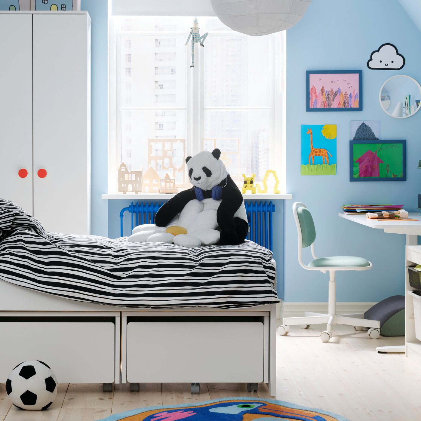 A children’s room with the SLÄKT bed in the middle made up with NATTHÄGER bedding, Wardrobes and window in background.