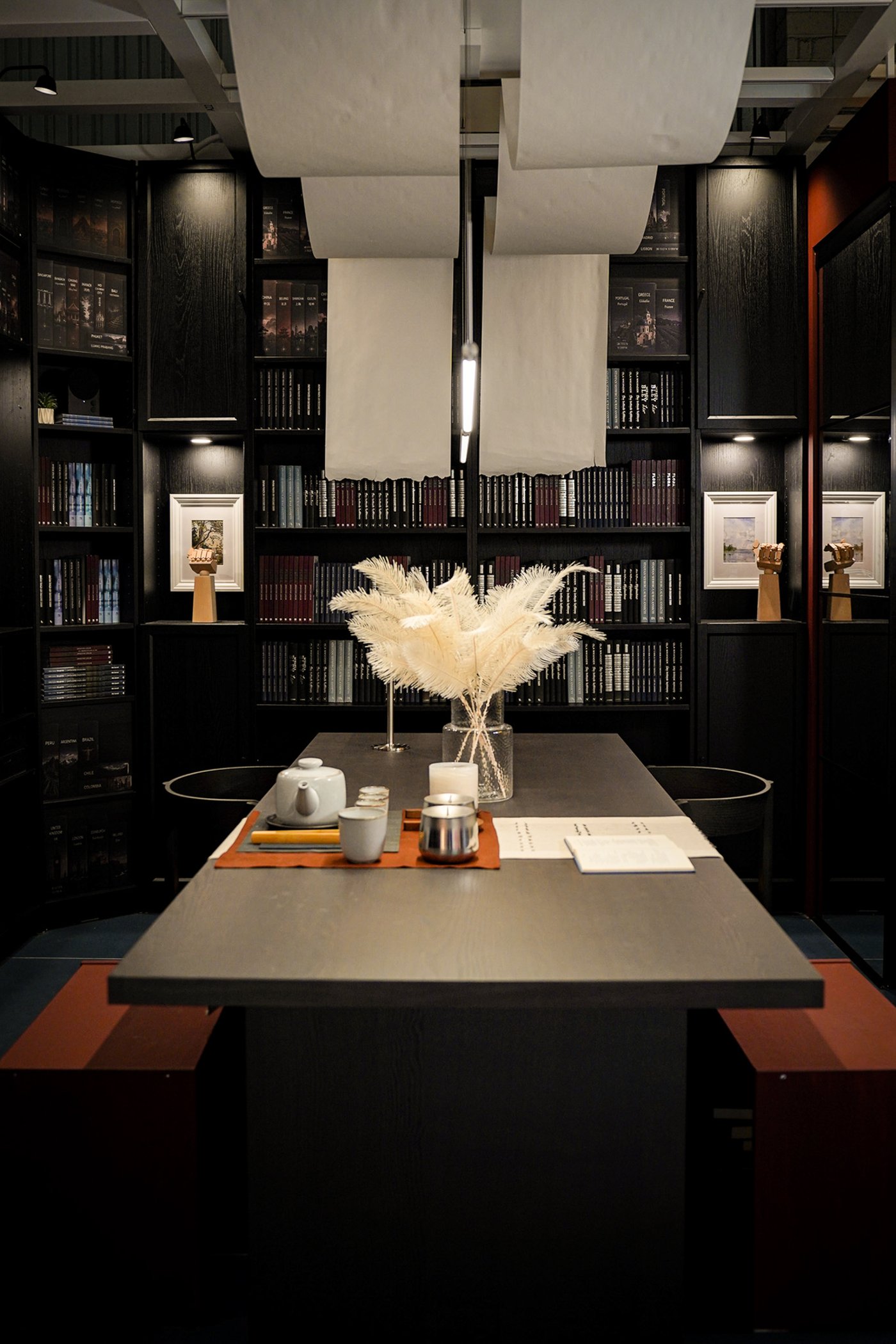 Curious Library room setting at IKEA Tampines, featuring a dark brown BERGSHYTTAN dining table, STOCKHOLM dining chair and black oak effect BILLY bookcases filled with books.