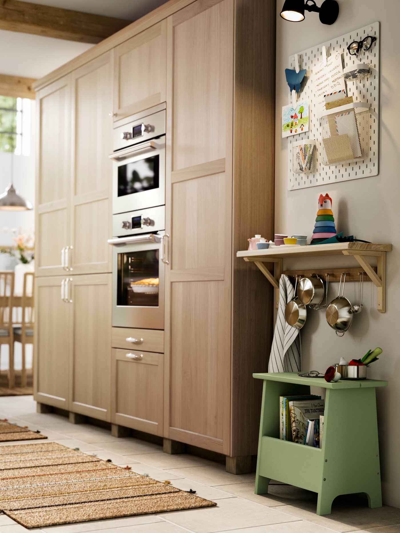 Es ein Küchenschrank mit Türen und Schubladen mit FORSBACKA Fronten in Eichenfurnier neben einem Regal mit Spielzeug zu sehen.