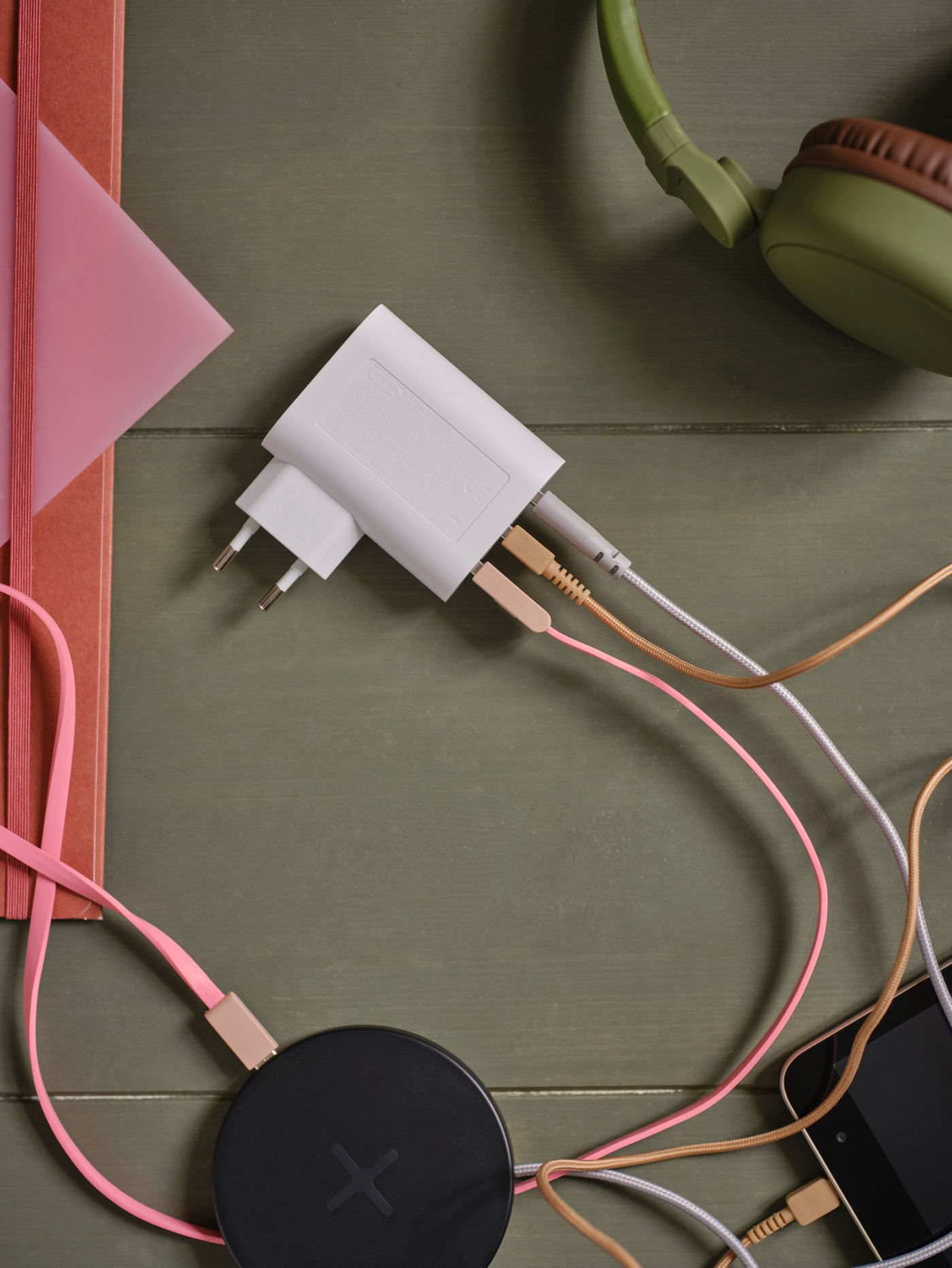 Een witte IKEA SMÅHAGEL USB-oplader met 3 poorten, met gekleurde USB-kabels erin gestoken.