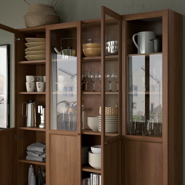 Part of a white room with side-by-side white BILLY bookcases fitted with OXBERG bottom-half-panel-top-half-glass doors.