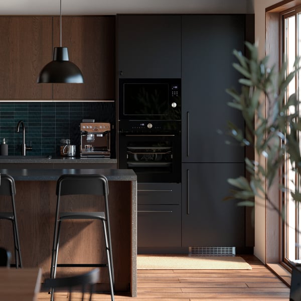 Współczesna kuchnia z wyspą kuchenną, brązowymi frontami SINARP i antracytowymi frontami NICKEBO z matowym wykończeniem.