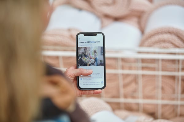 En person holder en mobil op foran sig mens hun tilmelder sig IKEA Family.