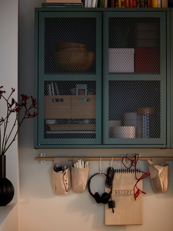 Wall-mounted, grey-green IVAR cabinets with mesh doors hold accessories and serveware. NEREBY birch rails are fitted below.