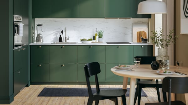 En IKEA 300 svart MATMÄSSIG induktionshäll i ett grönt kök.