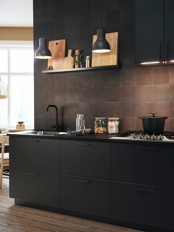 The dramatic darkness of this kitchen with anthracite KUNGSBACKA fronts is offset by light wood and bamboo accessories.