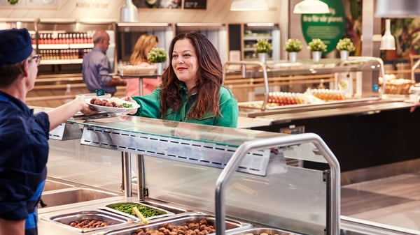Un collaborateur remet un repas pour adulte à une cliente au Restaurant suédois.