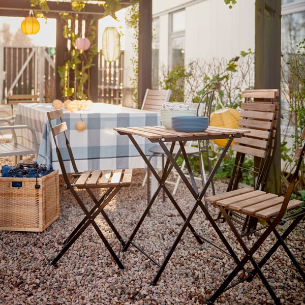 A foldable black/light brown stained TÄRNÖ chair, outdoor outside