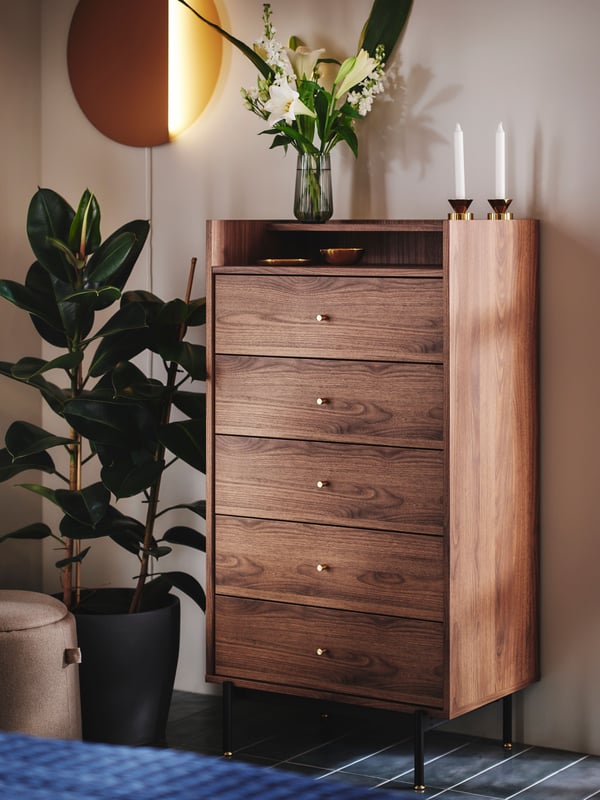 A dark grey PERSILLADE plant pot in the bedroom with a RÅDMANSÖ chest of drawers standing against the wall. 