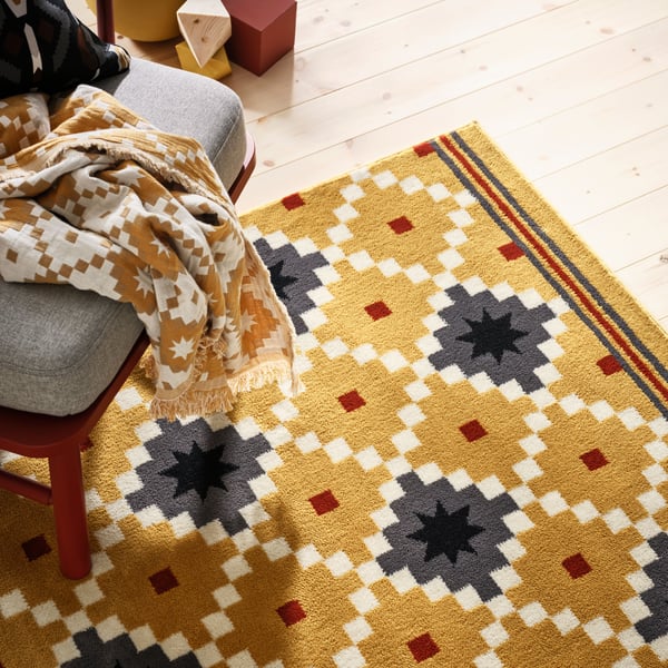 A dark yellow/dark grey SKOTERLED rug, low pile in the NA
