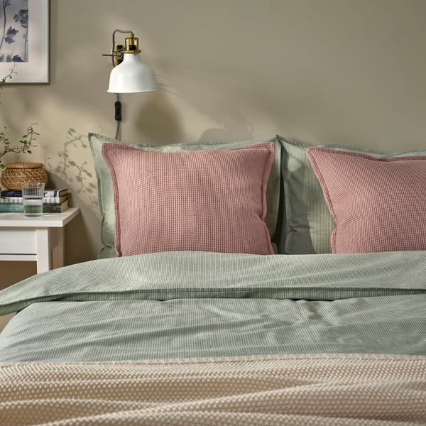A pale pink KLOTSTARR cushion cover