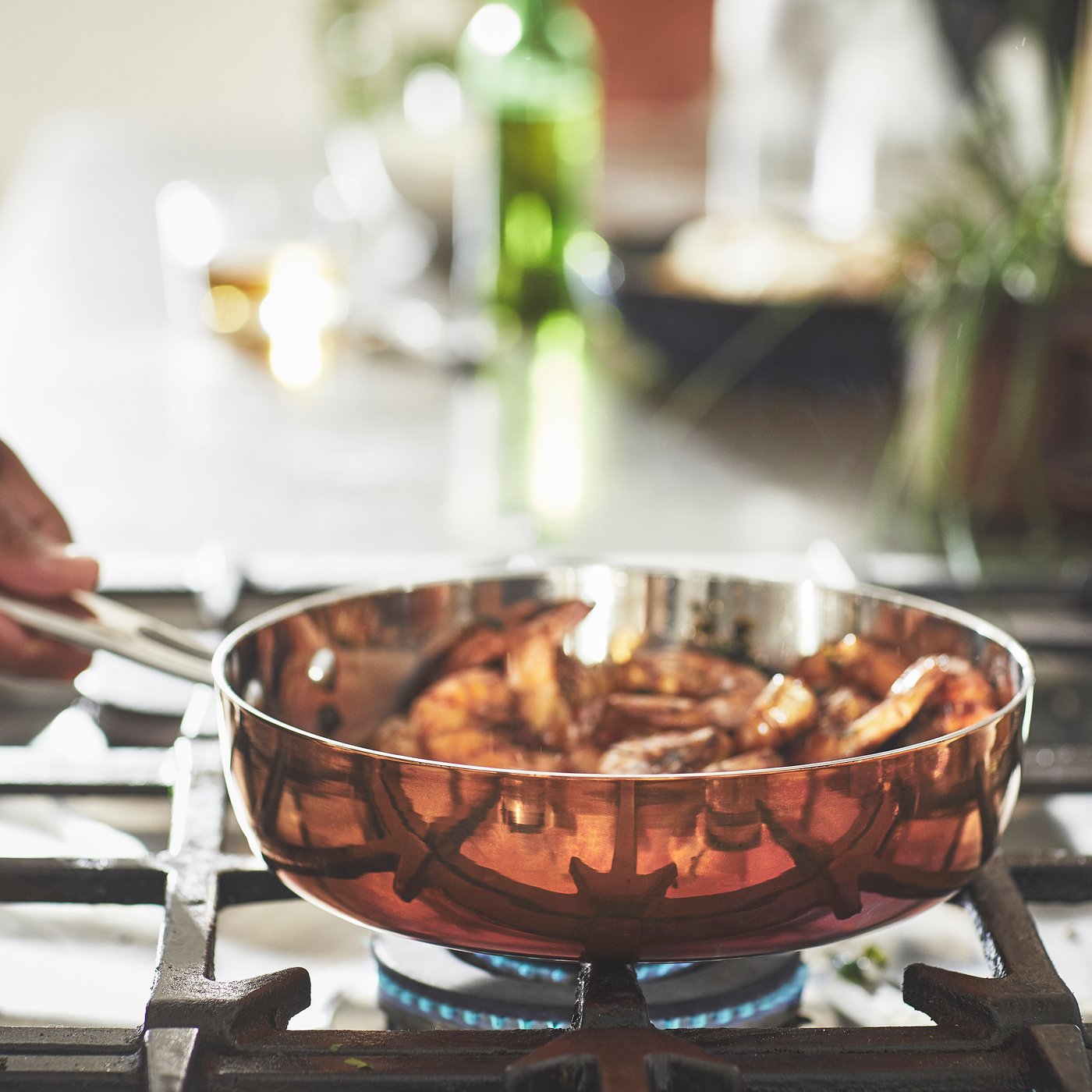 A copper/stainless steel FINMAT sauté pan with lid