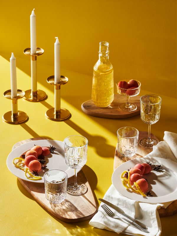 An ivory/gold-colour GLITTRIG candlestick in the dining room