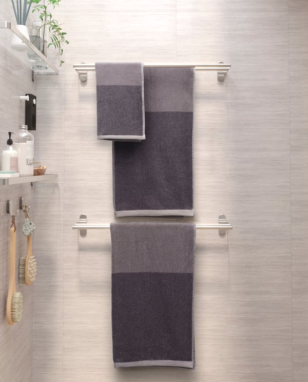 A dark grey/mélange HIMLEÅN bath towel in the bathroom