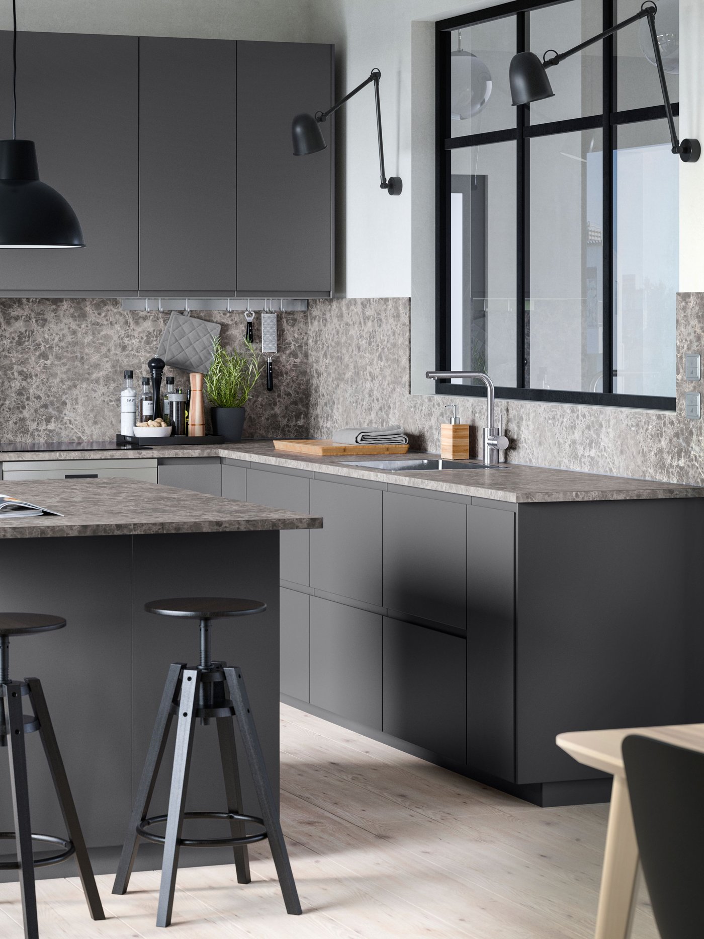 Et mørkegråt køkken med en køkkenø med to barstole.