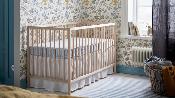 Una habitación infantil con una cuna SINGLAR con el colchón elevado.