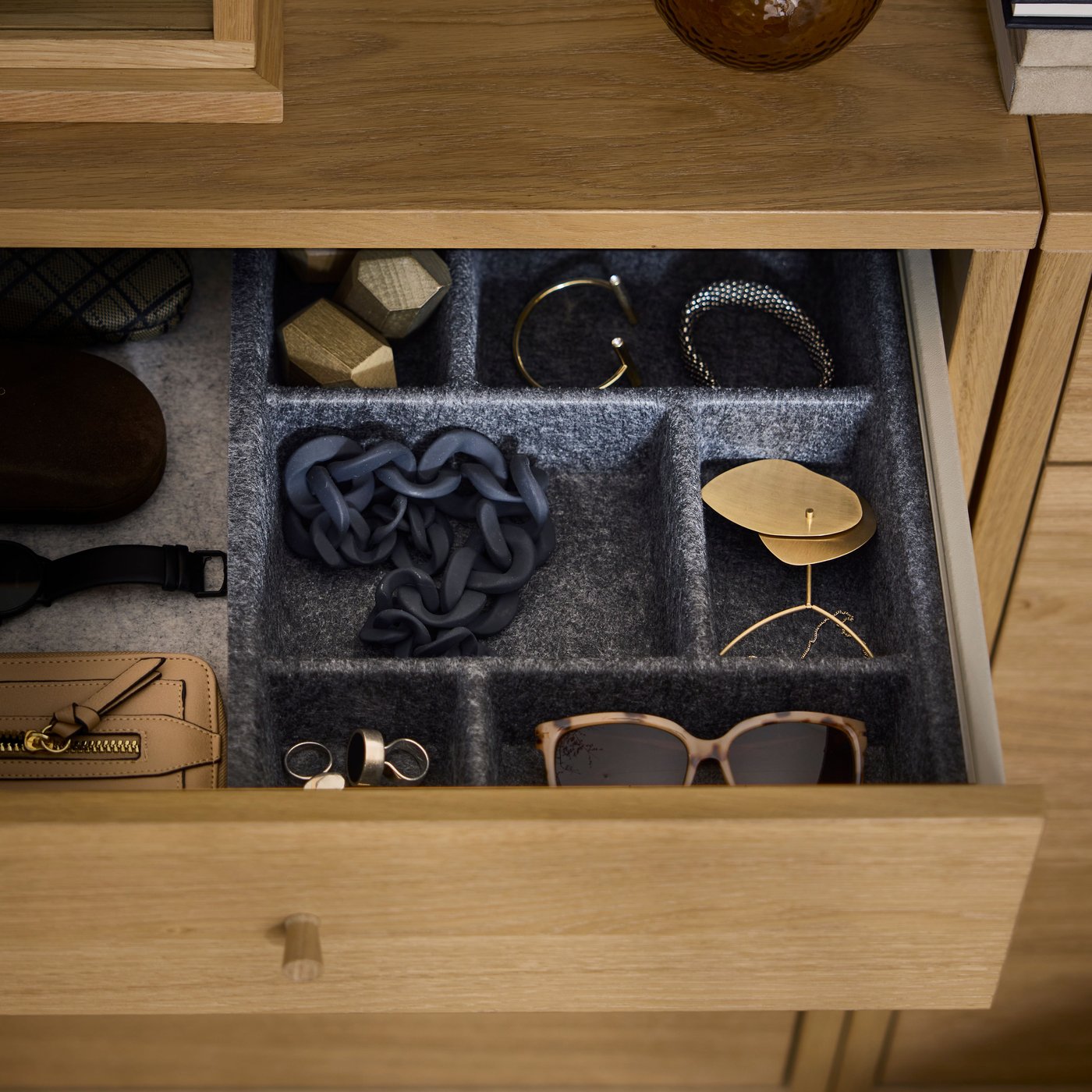 Close-up of the open top drawer in a wooden chest of drawers, showing the neat order with RAGGISAR organizers inside.