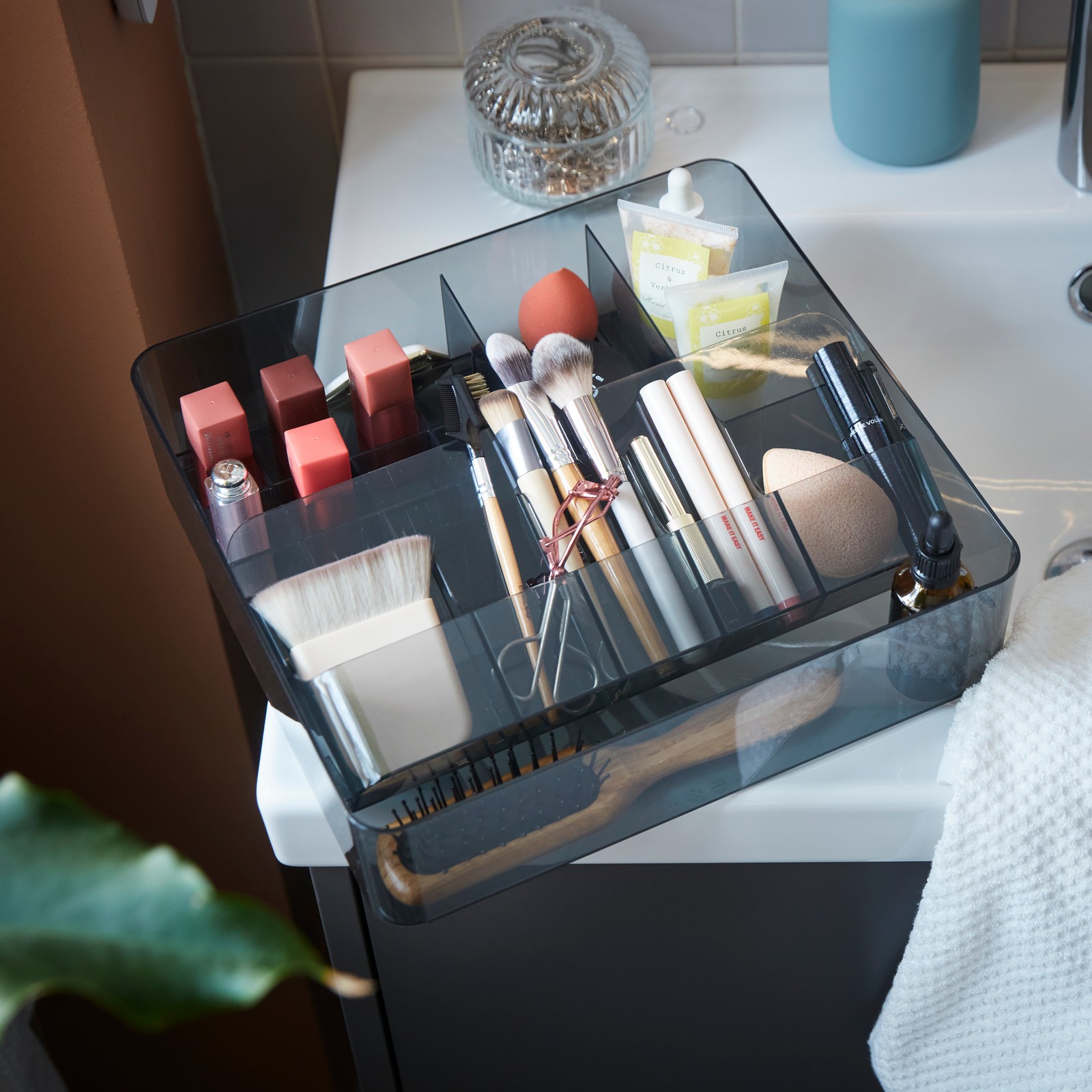 A close-up on a grey VISSLAÅN box with compartments neatly organised with various beauty tools and products.