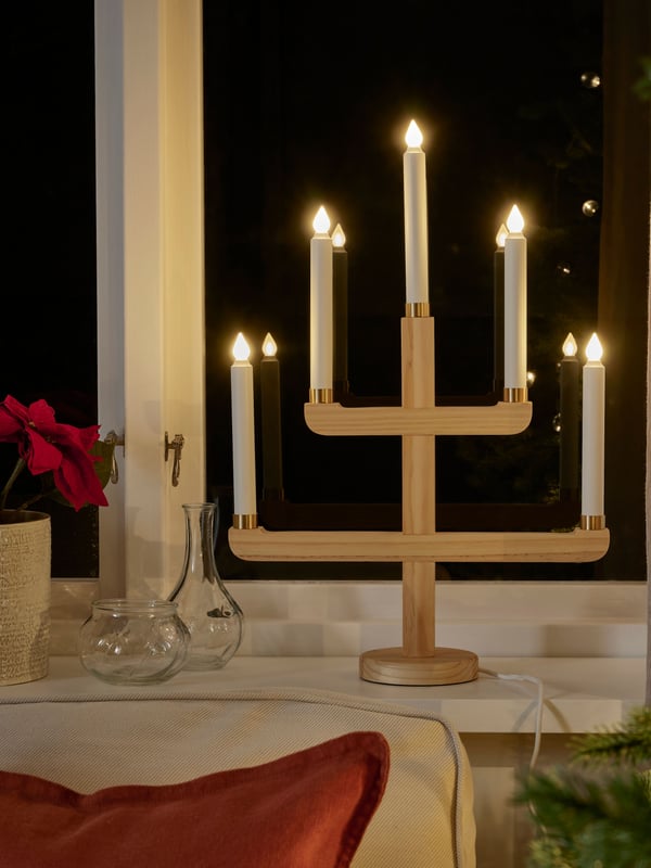 STRÅLA adventslys på et bord foran et vindu.