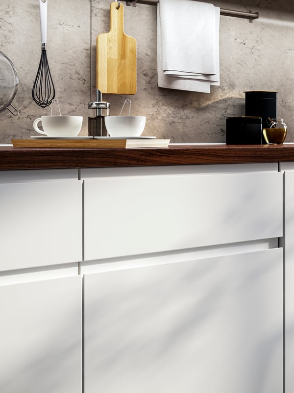 A close up of a kitchen cabinet with IKEA VOXTORP matt white drawers.