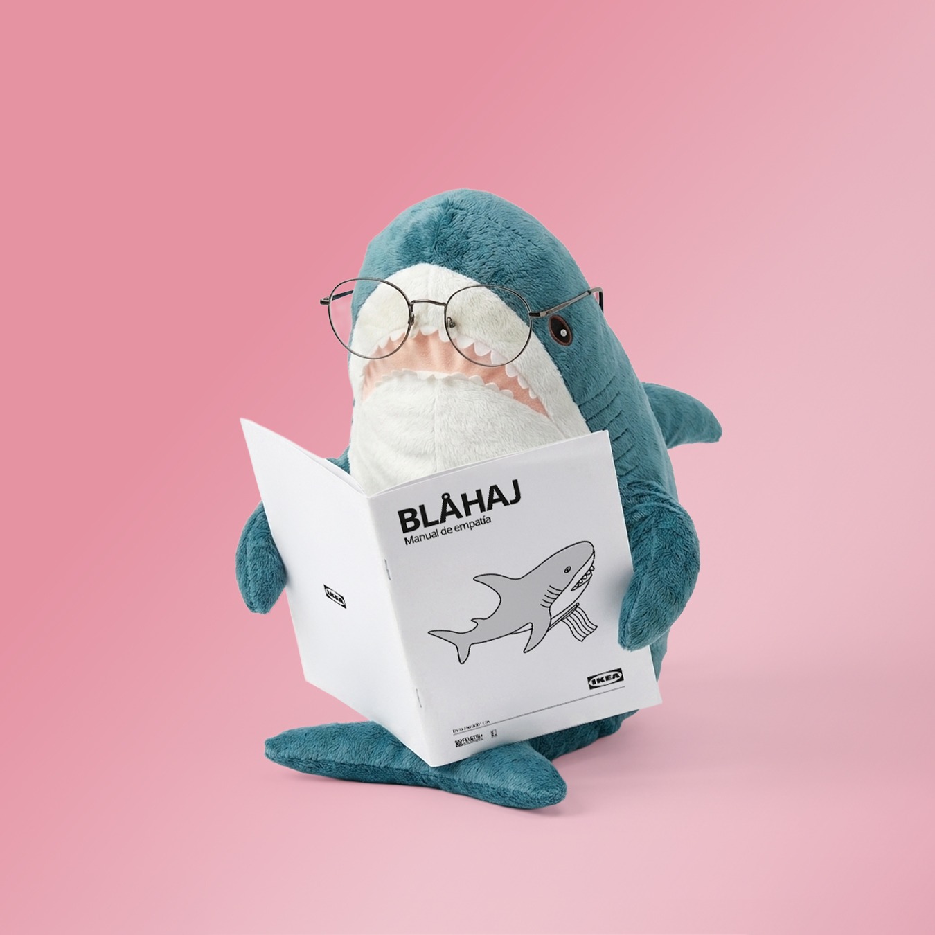 El peluche BLÅHAJ leyendo el Manual de Empatía creado por IKEA en colaboración con la Federación Estatal LGTBI+ para apoyar a la comunidad trans.