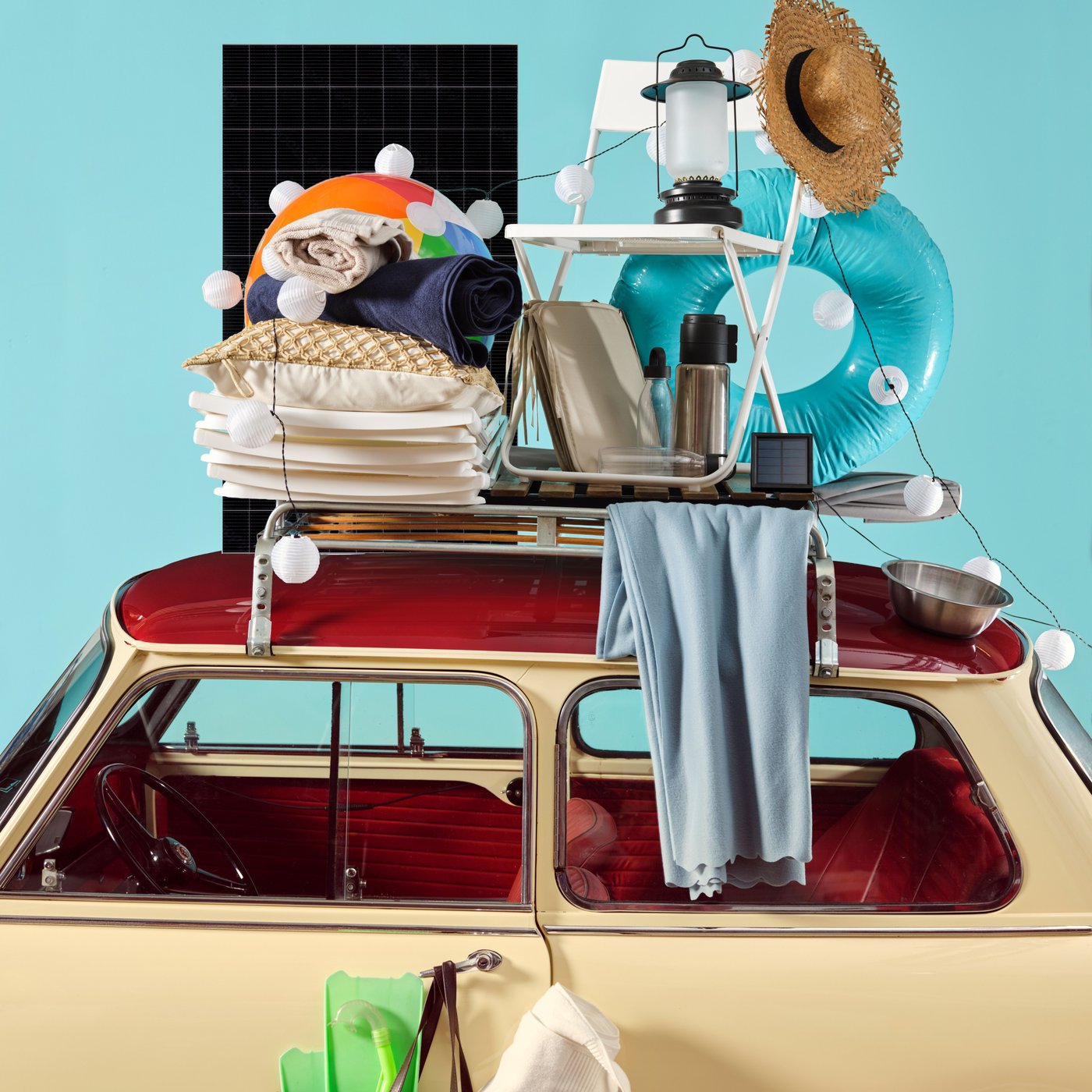 Een oldtimer volgeladen met kleurrijke IKEA-kampeer- en strandspullen, van serviesgoed en textiel tot een draagbare lamp, zorgt voor een speels zomers tafereel.