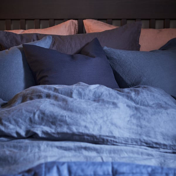 A PUDERVIVA quilt cover and pillowcase in dark blue on a bed.