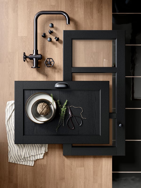 A mood board with black LERHYTTAN fronts and a black tap.