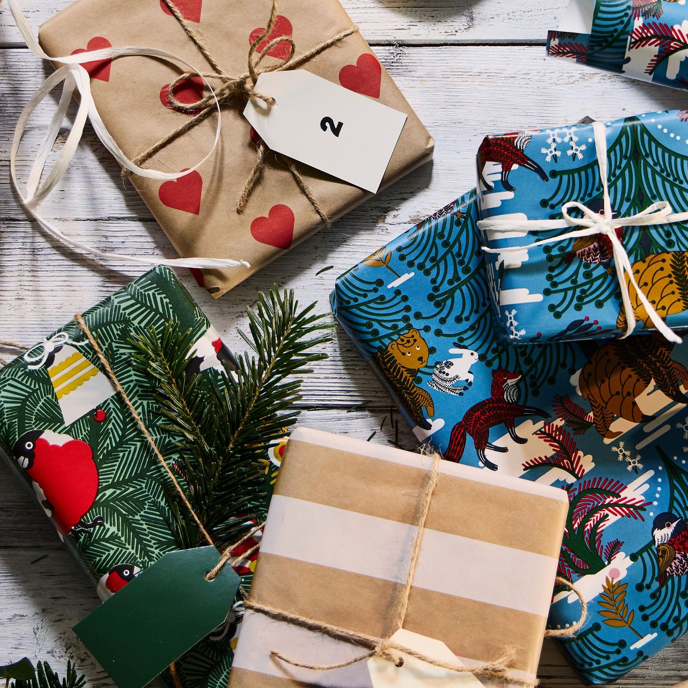 Weihnachtsgeschenke in VINTERFINT-Geschenkverpackung mit Herz-, Streifen- und schwedischem Waldmotiv.